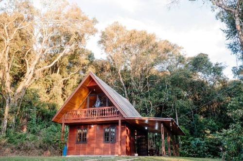 a small wooden cabin in the middle of a forest at Chalé lua cheia in Flores da Cunha