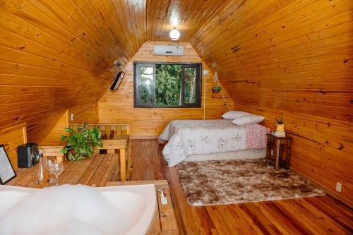 a bedroom with a bed in a wooden cabin at Chalé lua cheia in Flores da Cunha