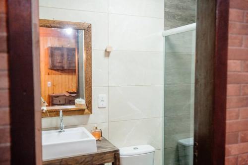 a bathroom with a sink and a mirror at Chalé lua cheia in Flores da Cunha