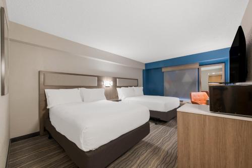 a hotel room with two beds and a flat screen tv at Holiday Inn Express Hotels- Hampton by IHG in Hampton