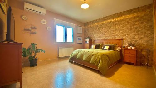 een slaapkamer met een bed en een stenen muur bij Puy du Fou alojamiento de Julieta in Bargas