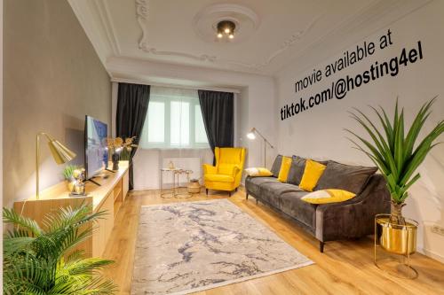 - un salon avec un canapé et un fauteuil jaune dans l'établissement Historical Center by 4EL, à Bucarest