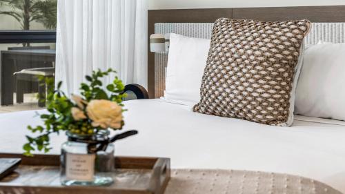 uma cama com uma almofada e uma mesa com flores em Private Residence at W South Beach -711 em Miami Beach