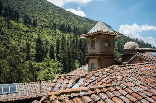 an old building with a tower on top of a roof at Hacienda Rumiloma in Quito