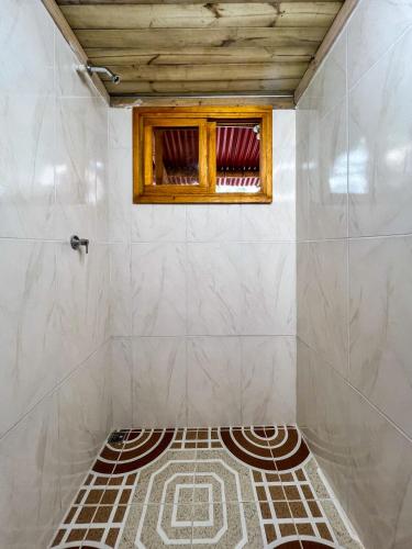 a bathroom with a window and a tiled floor at Tayrona Cachaco River Ecohostal in El Zaino