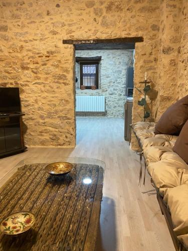 uma sala de estar com um sofá e uma mesa em La Casona de 1717 em El Burgo de Osma