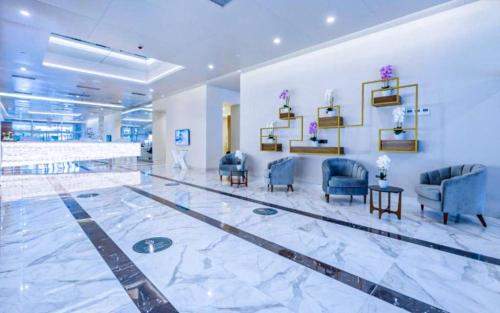a lobby with blue chairs and tables in a building at Luxury Apartments in Batumi