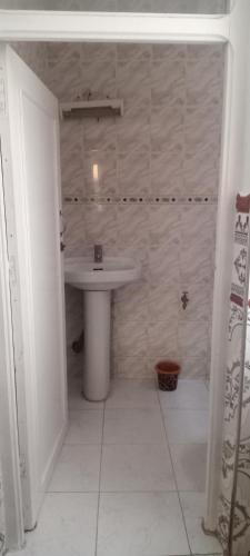 y baño con lavabo blanco y aseo. en Appartement meublé à Mdiq vue sur mer à 16 RL 2 Avenue KADI AYAD app 5 code postale 93200 la rue entre auto-école et dawajin al khayrat, en M'diq