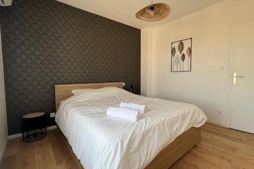 une chambre avec un lit avec deux serviettes dessus dans l'établissement Le Melo - Charmant appartement T2 neuf, à Perpignan