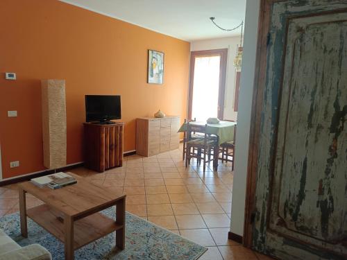 a living room with a tv and a table at L'angolo di Anna in Pieve di Soligo