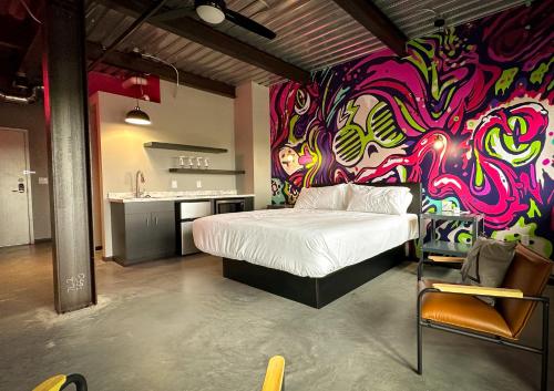 a room with a bed and a colorful wall at Brewhalla Hotel in Fargo