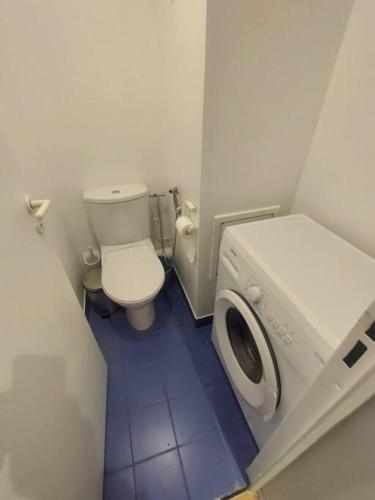une petite salle de bains avec toilettes et lave-linge. dans l'établissement 7mn walk to Metro, in ApartHotel, à Courbevoie