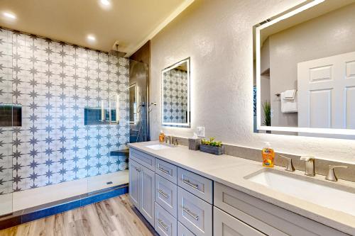 baño con 2 lavabos y espejo grande en Sun Daze, en Oro Valley