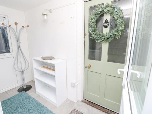a bathroom with a door and a wreath on it at Saltwater Cottage in Ventnor
