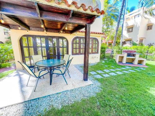eine Terrasse mit einem Tisch und Stühlen im Hof in der Unterkunft Garden & Ocean View VILLAS & Apartments WiFi BBQ Beach CLUB & SPA in Punta Cana