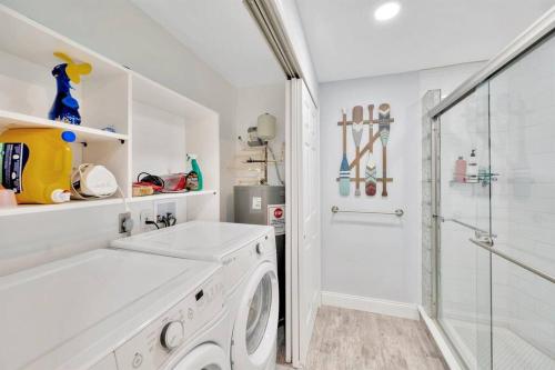 a white bathroom with a washing machine and a shower at Island Paradise 3 Bed Waterfront/Heated Pool in Clearwater Beach
