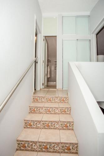 a staircase in a house with white walls and tile floors at EcoMar Rentals: Villa in Cabo Rojo
