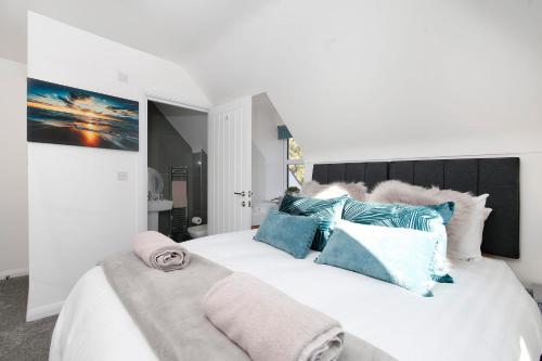 a bedroom with a large white bed with blue pillows at Nightingale - Perfect location close to the Beach - Free Parking in Bournemouth