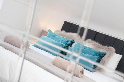 a bed with blue and white pillows on it at Nightingale - Perfect location close to the Beach - Free Parking in Bournemouth