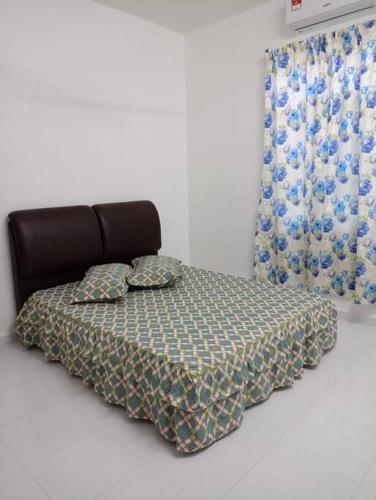 a bed with a blanket and pillows on it at Homestay Usrati 17J (untuk muslims sahaja) in Kangar