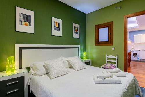 1 dormitorio con 1 cama blanca grande y paredes verdes en Apartment Alameda, en Sevilla