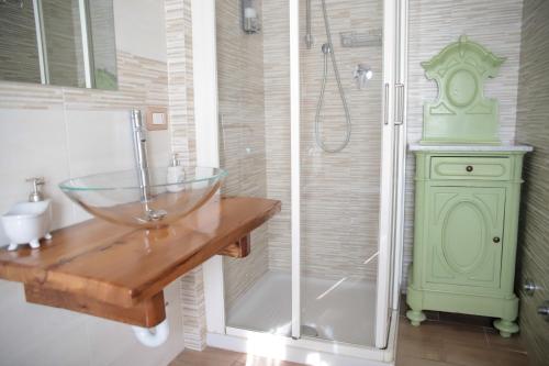 een badkamer met een glazen wastafel en een douche bij Antico Pioppo in Sale
