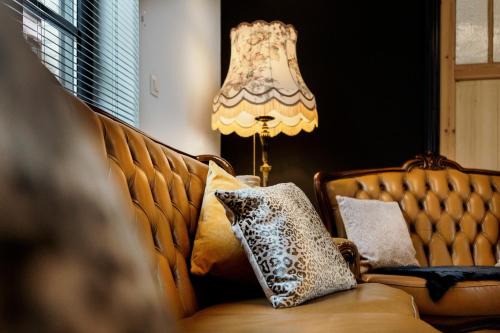 eine Couch mit Kissen darauf neben einer Lampe in der Unterkunft Huis 7 in Ypern