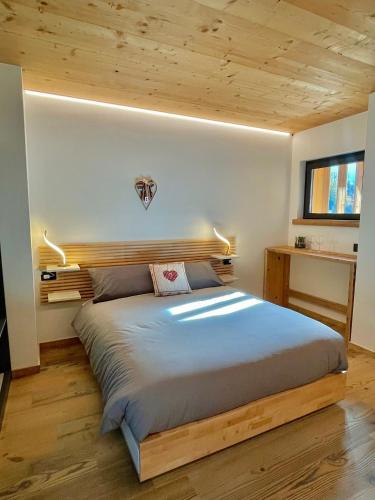 - une chambre avec un grand lit et une tête de lit en bois dans l'établissement Le Stue, à Pieve di Cadore