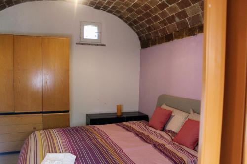 una camera da letto con un letto con cuscini rossi di La Casina a Montecatini Val di Cecina