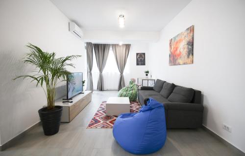 a living room with a couch and a blue ottoman at Vitan Central Oasis - NEW Building - FREE Secured Private PARKING - Self Check-in - in Bucharest