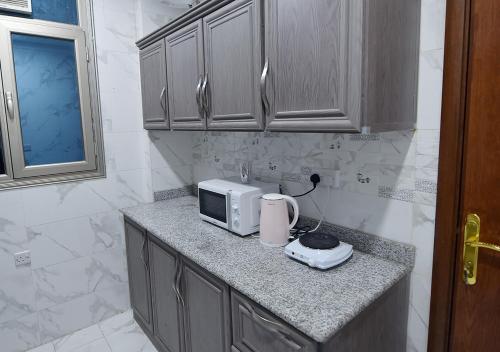um balcão de cozinha com um micro-ondas e uma torradeira em الدانة للشقق الفندقية em Kuwait