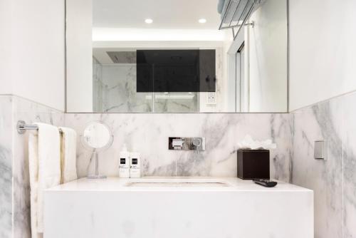 bagno bianco con lavandino e specchio di Marques Best Apartments | Lisbon Best Apartments a Lisbona