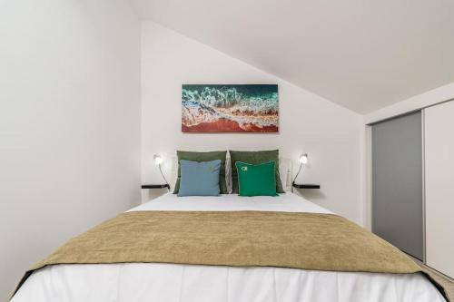 a white bedroom with a bed with green pillows at Ribeiro´s House, New apartment with amazing sunsets in Arco da Calheta
