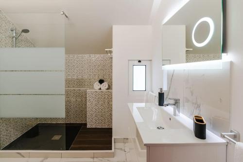 a white bathroom with two sinks and a shower at Ribeiro´s House, New apartment with amazing sunsets in Arco da Calheta