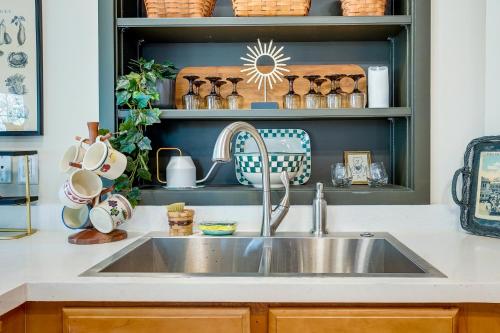 a kitchen with a sink and a shelf with dishes at Charming Granville Home with Porch - Walk Downtown! in Granville