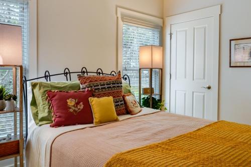 a bedroom with a bed with red and yellow pillows at Charming Granville Home with Porch - Walk Downtown! in Granville