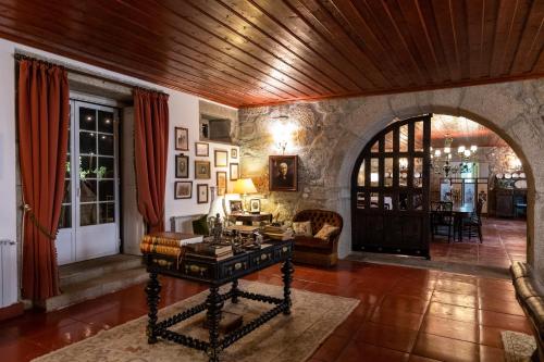 a living room with a wooden ceiling and a table at Casa do Cimo in Aldeia Nova do Cabo