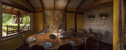 a dining room with a table and a painting on the wall at Hacienda Rumiloma in Quito