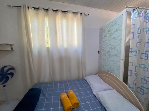 a small bedroom with a bed with yellow objects on it at Itajaí Hostel Pousada in Itajaí