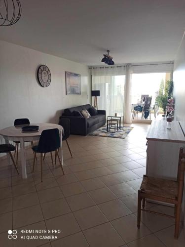 un salon avec un canapé et une table dans l'établissement sous le soleil de l'ILE ROUSSE, à LʼÎle-Rousse