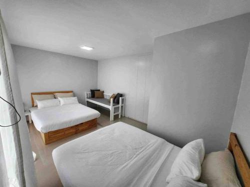 1 dormitorio pequeño con 2 camas y 1 silla en Monon Antipolo Japanese Onsen Feels, en Antipolo