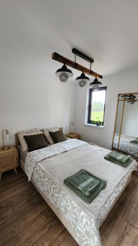 biała sypialnia z dużym łóżkiem i oknem w obiekcie Jurajskie Stodoły w mieście Częstochowa