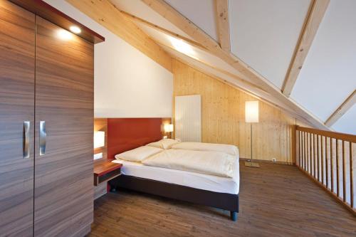a bedroom with a bed in the middle of a room at Hotel Alte Post in Feld am See