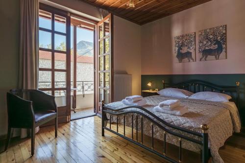 um quarto com uma cama e uma grande janela em Chrysiida Apartments Kalavrita em Kalavrita