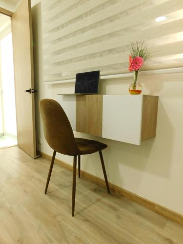 a desk with a chair and a laptop on a wall at HOTEL MX BOGOTA in Bogotá