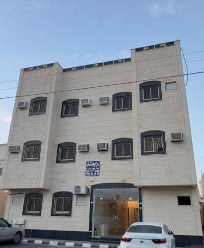 un edificio con un coche aparcado delante de él en رغيد للشقق الفندقية حائل, en Hail