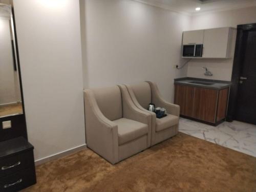a living room with a couch and a kitchen at كازا رست للوحدات السكنية in Ḩayy aş Şāliḩīyah