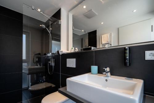 Mood contemporary living في مانهايم: حمام مع حوض ومرحاض ومرآة