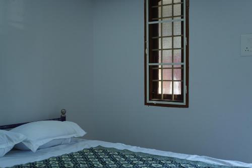 a bedroom with a bed and a window at Prism Holiday Resort PONDICHERRY Kalapet in Kālapettai