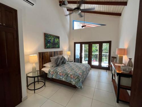 a bedroom with a bed and a desk and a window at Aracari Lodge & Jungalows in Middlesex